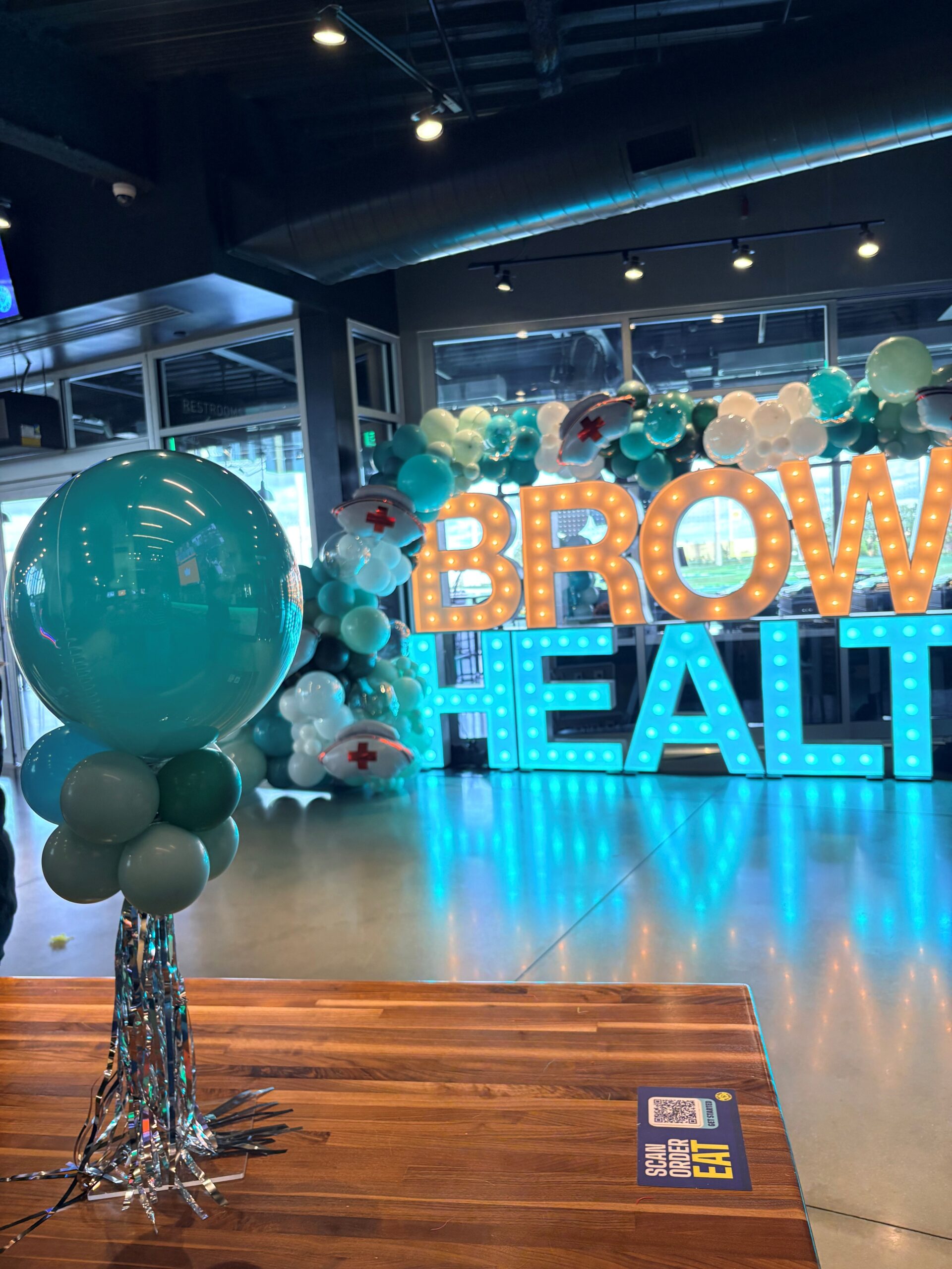 Brown Health branded balloon garland detail by Caliella, corporate balloon décor in Rhode Island 2026